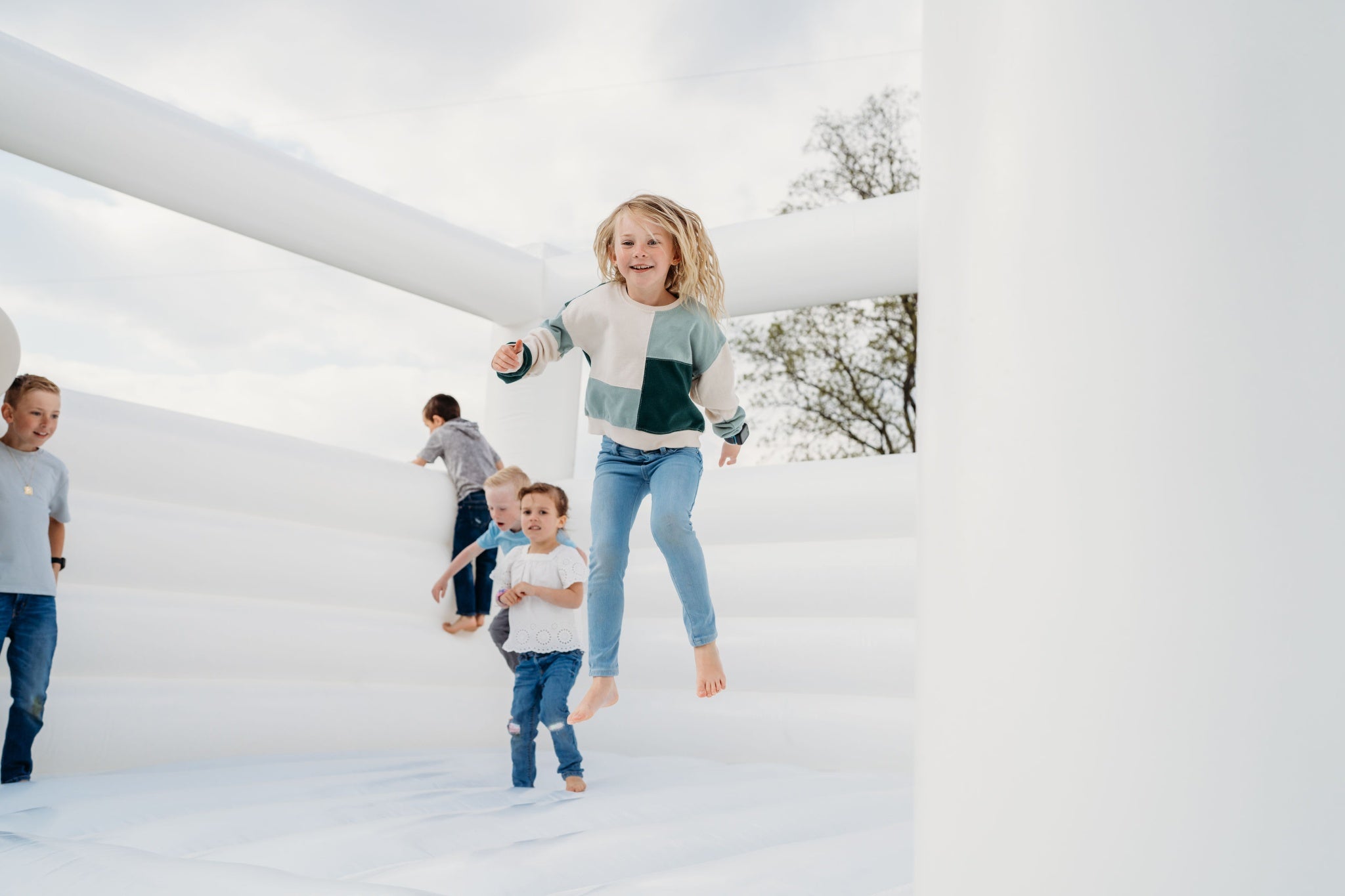 outdoor photo of kids bouncing in a bounce house