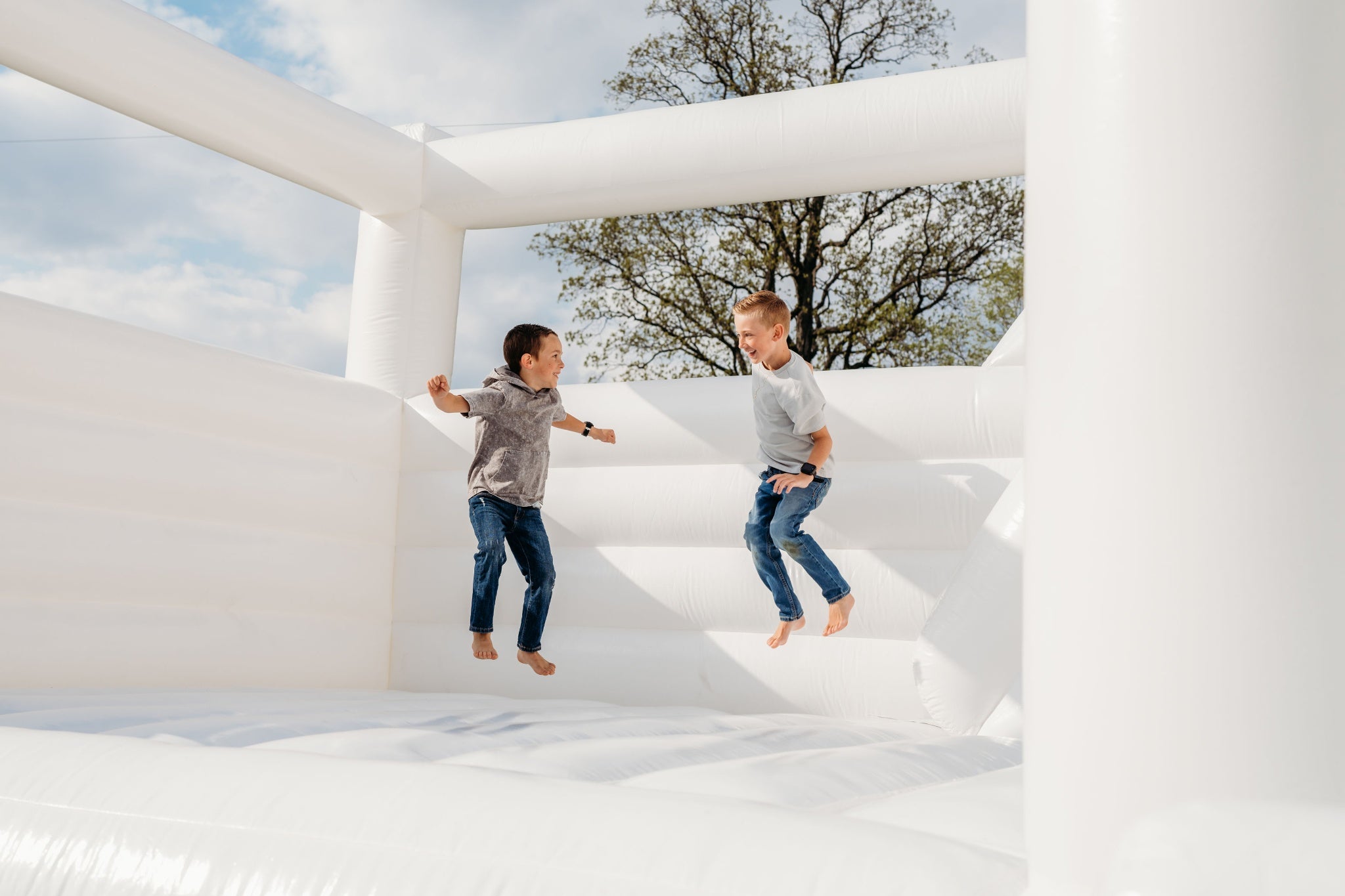 photo of two boys bouncing on a bounce house